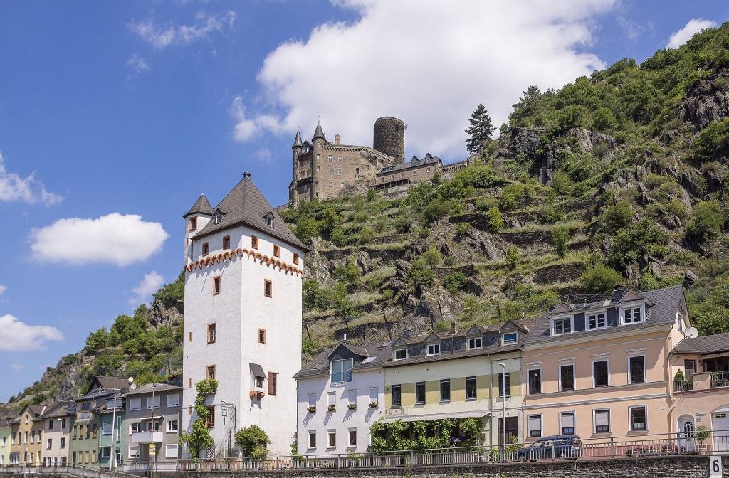 The houses of Sankt Goarshausen and a white medieval tower beside the Rhine, with Burg Katz on the hill above