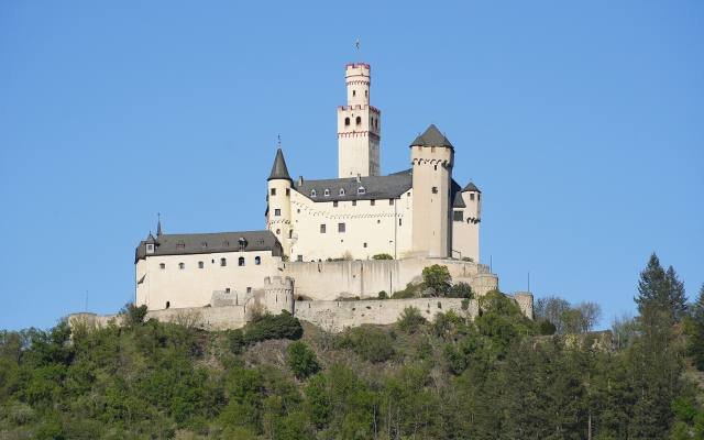 The white walls and tall keep of the Marksburg on its hilltop above Braubach